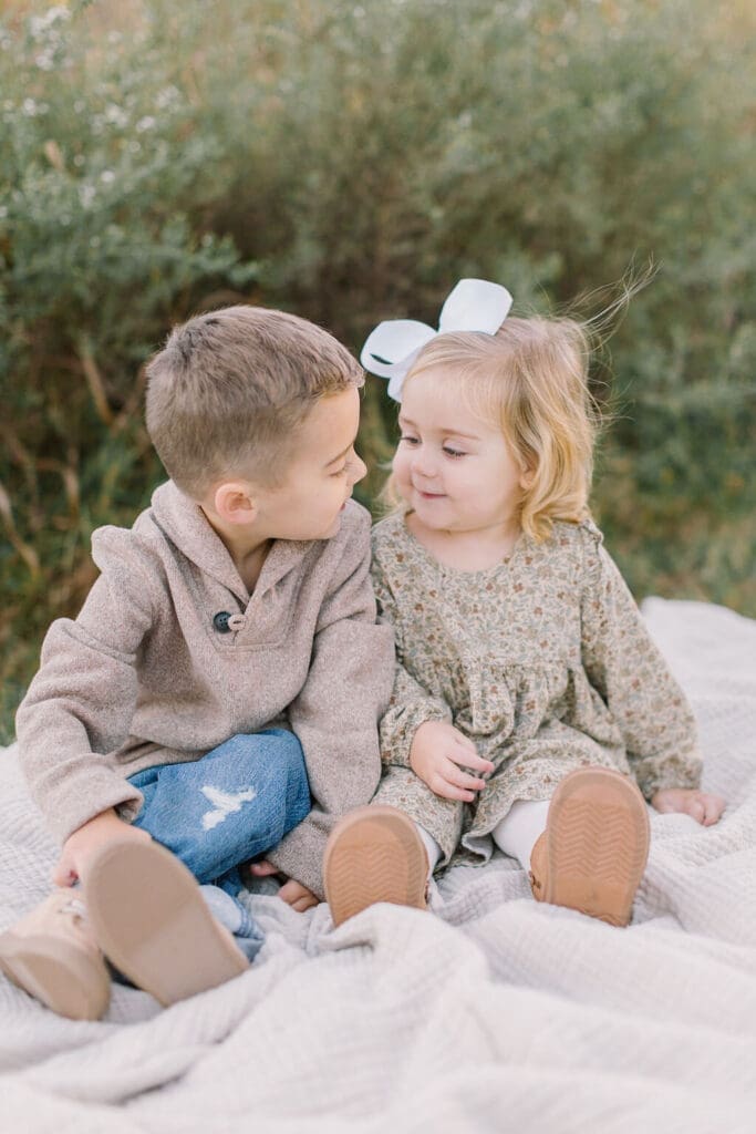 Brother and sister sitting close on a blanket during a Raleigh family session, sharing a sweet sibling moment in a soft and natural setting.
Prepare your Raleigh family photo session. This is a Raleigh Family Photo Style Guide helping you choose colors and clothes.