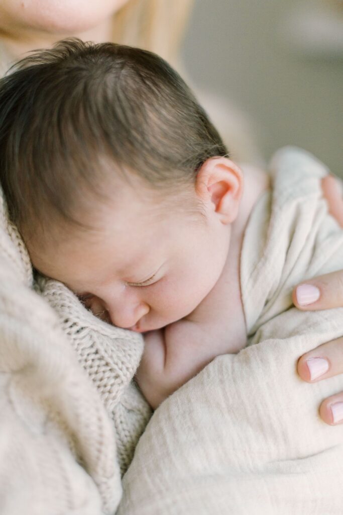 A sleepy newborn rests peacefully against a parent during an in-home session with Lindsey Lambert Photography, shared as part of these newborn session tips.