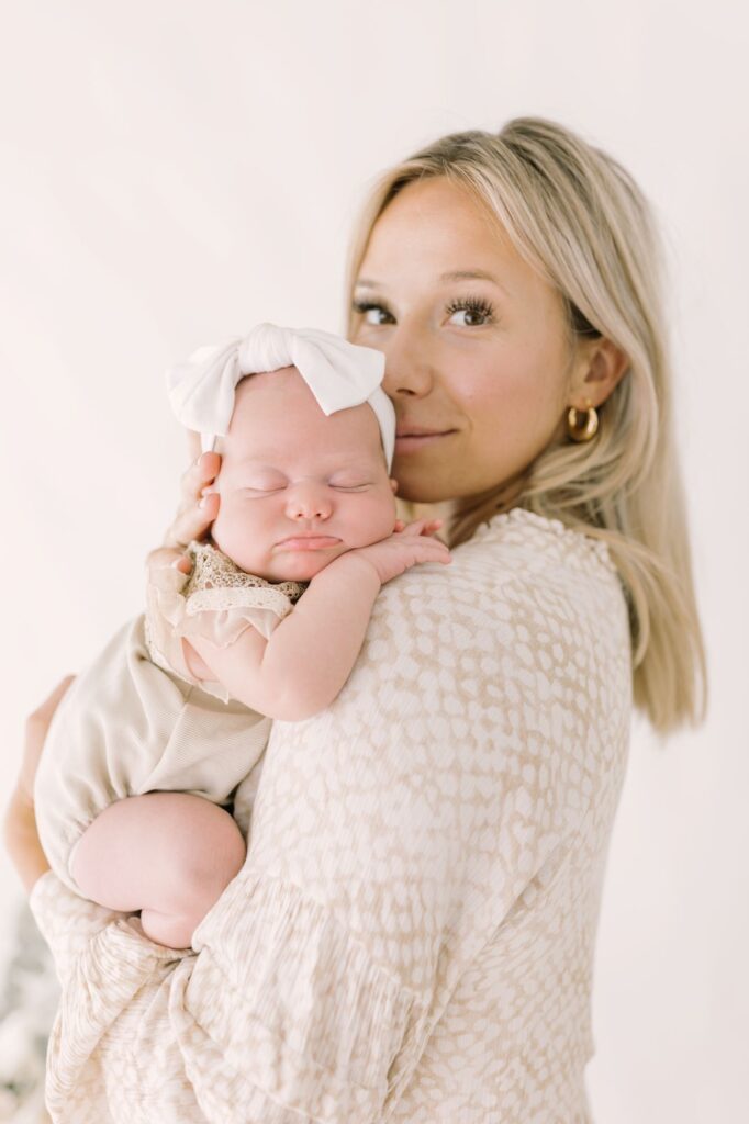 Mom holding her sleeping newborn baby girl during a Raleigh newborn session by Lindsey Lambert Photography. 