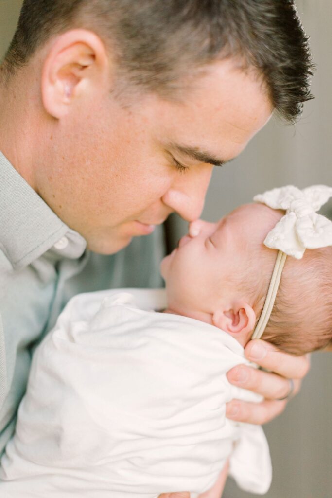 Dad touching noses with his newborn baby girl - newborn photos Raleigh NC by Lindsey Lambert Photography.
