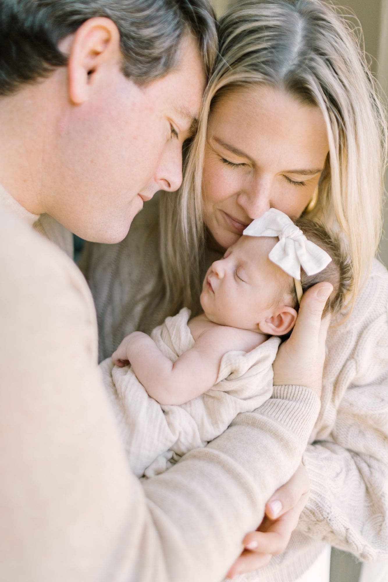 Dad holding baby while mom nuzzles her at Raleigh newborn session