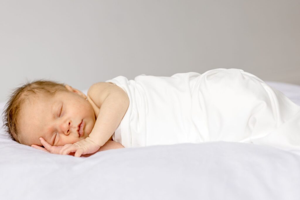Newborn baby resting in a cozy pose photographed by Lindsey Lambert Photography in Raleigh NC for a blog about when to take newborn photos.