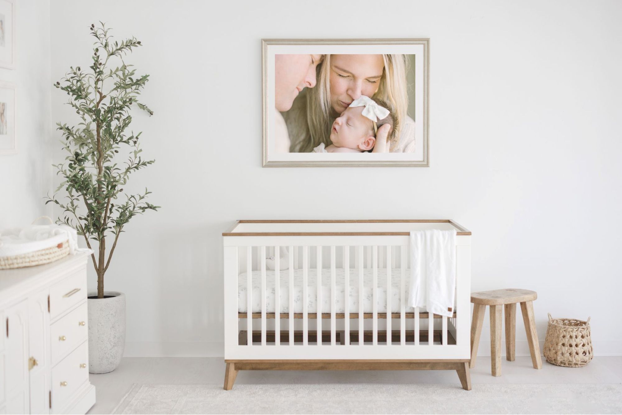 Photo gallery wall ideas featuring a framed mother and baby portrait above a crib, designed to create a meaningful nursery focal point by Lindsey Lambert Photography.