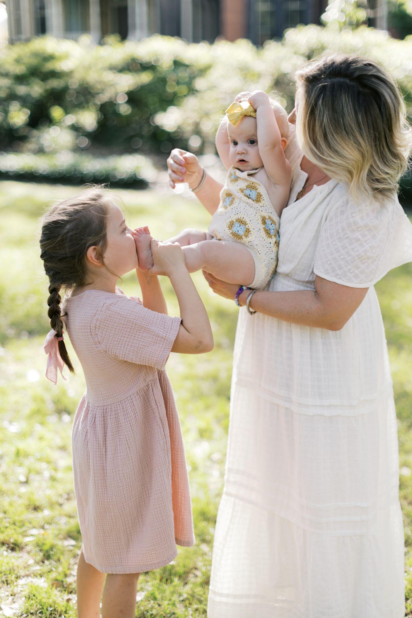 Mom and daughters wearing light and airy summer family photo outfits during a Raleigh NC family photography session by Lindsey Lambert Photography.