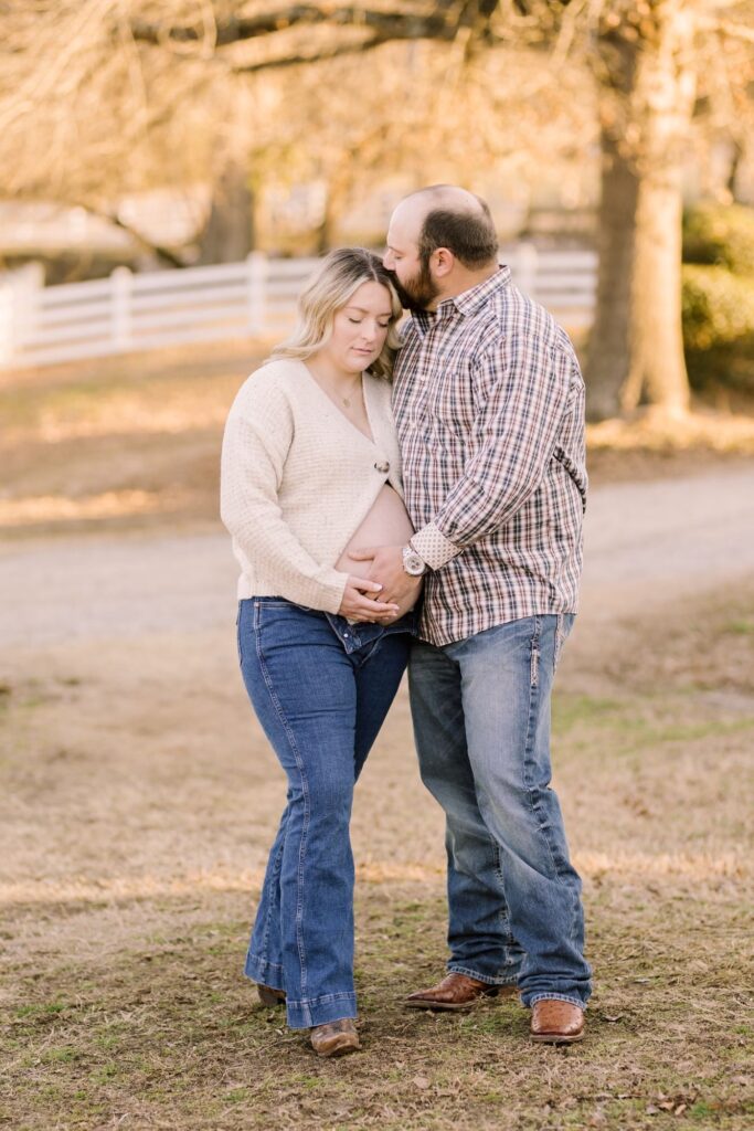 Couple embracing during a sunset maternity session demonstrating the best time to do maternity photos in Raleigh NC.